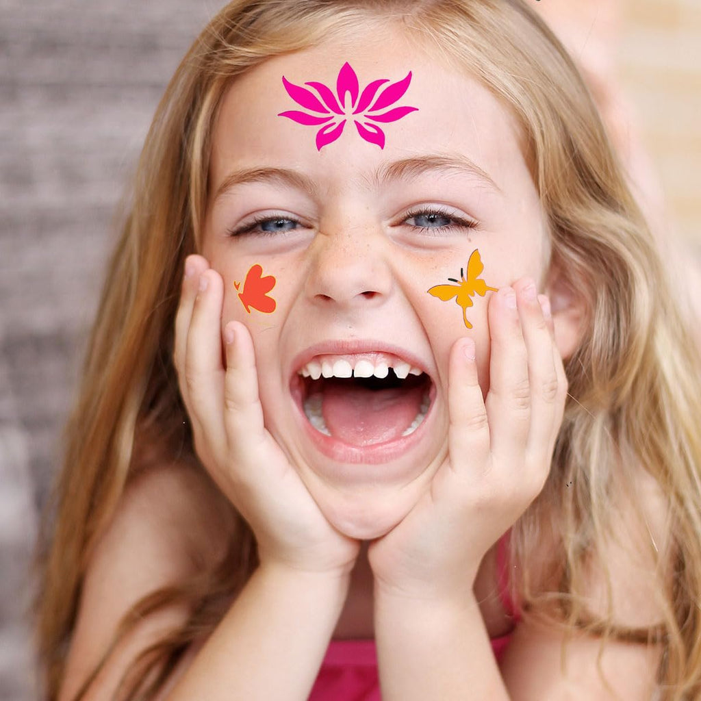 Young girl with face paint stencils of a pink lotus and orange butterflies laughing