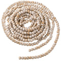 Coiled strand of rustic wooden beads with a distressed white and natural wood finish, isolated on a white background.
