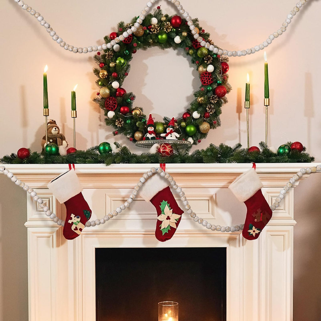 Christmas fireplace decorated with a wreath, stockings, and wood bead garland.