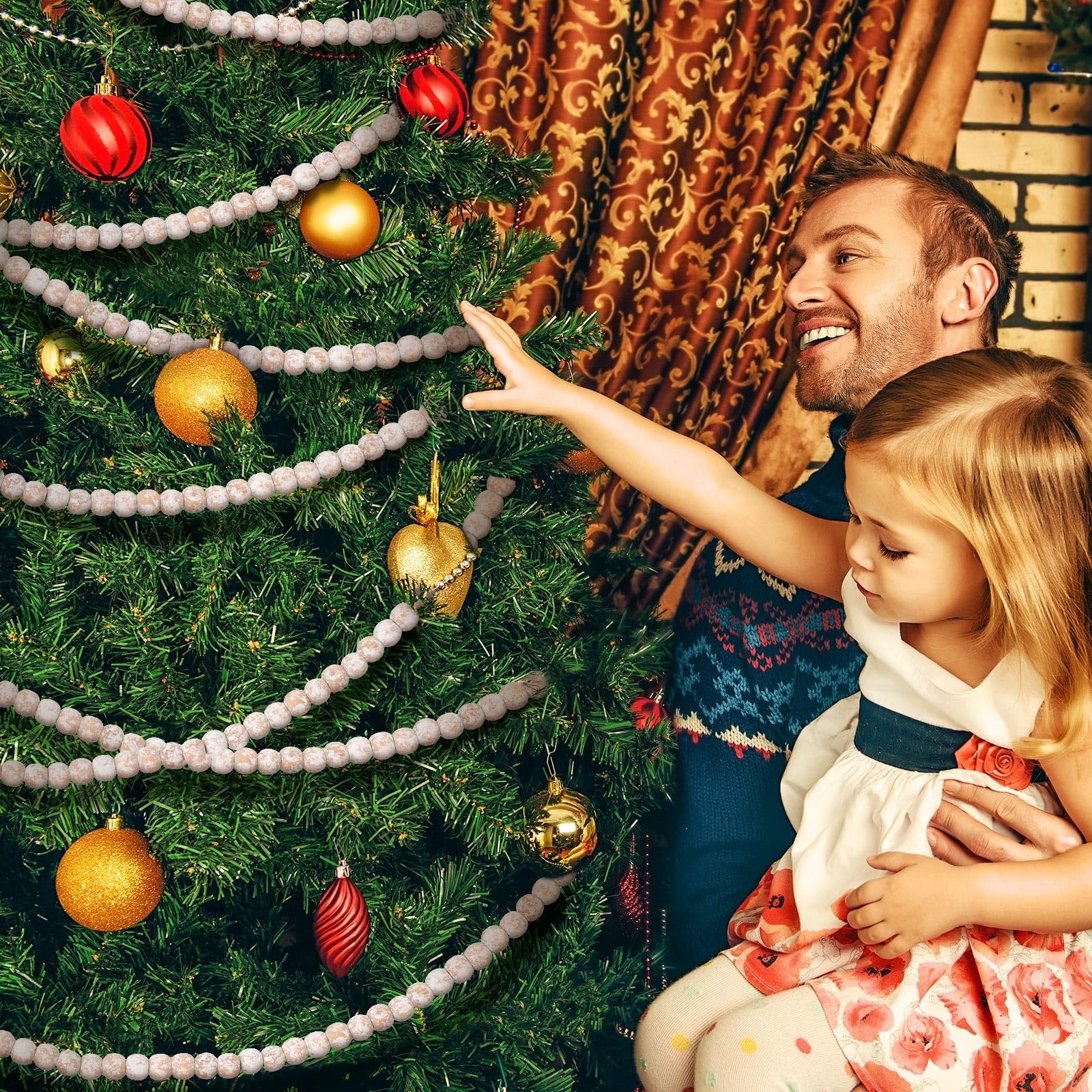 Father and daughter decorating a Christmas tree with wood bead garland and ornaments.