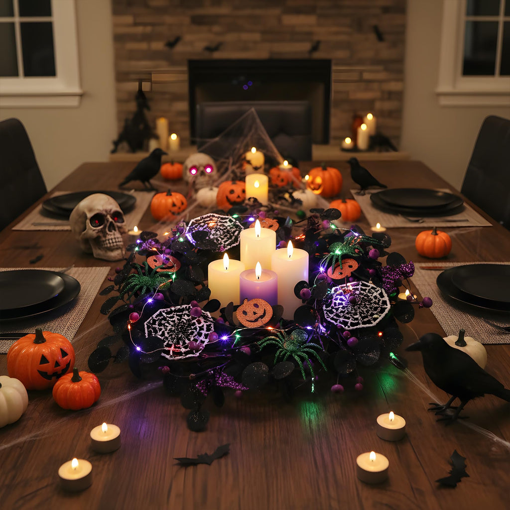 Halloween table setting with a wreath, pumpkins, skull, crows, and candles.