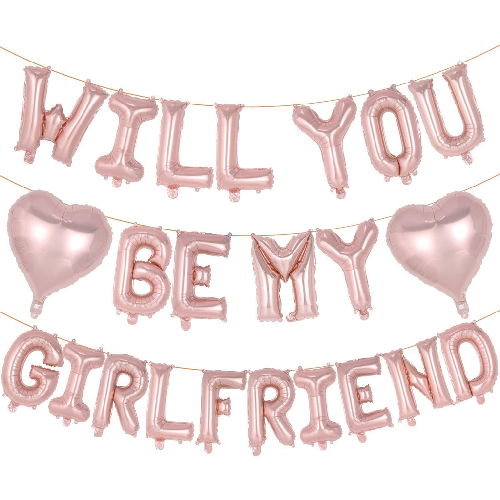 Rose gold foil balloons spelling 'Will You Be My Girlfriend' with two heart balloons, strung on a wire.