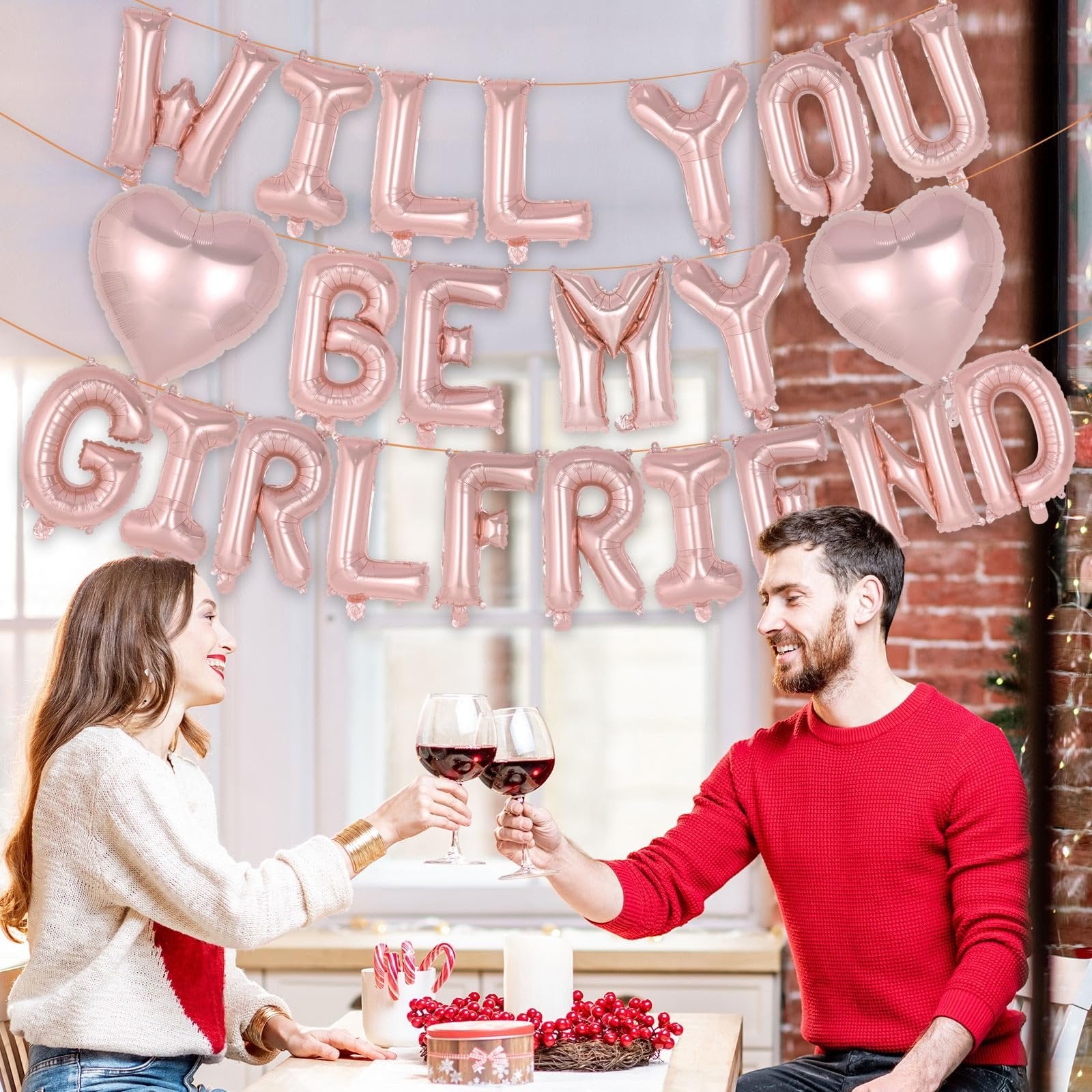 Rose gold foil balloons spelling "Will You Be My Girlfriend" with heart shapes, above a couple toasting with wine.