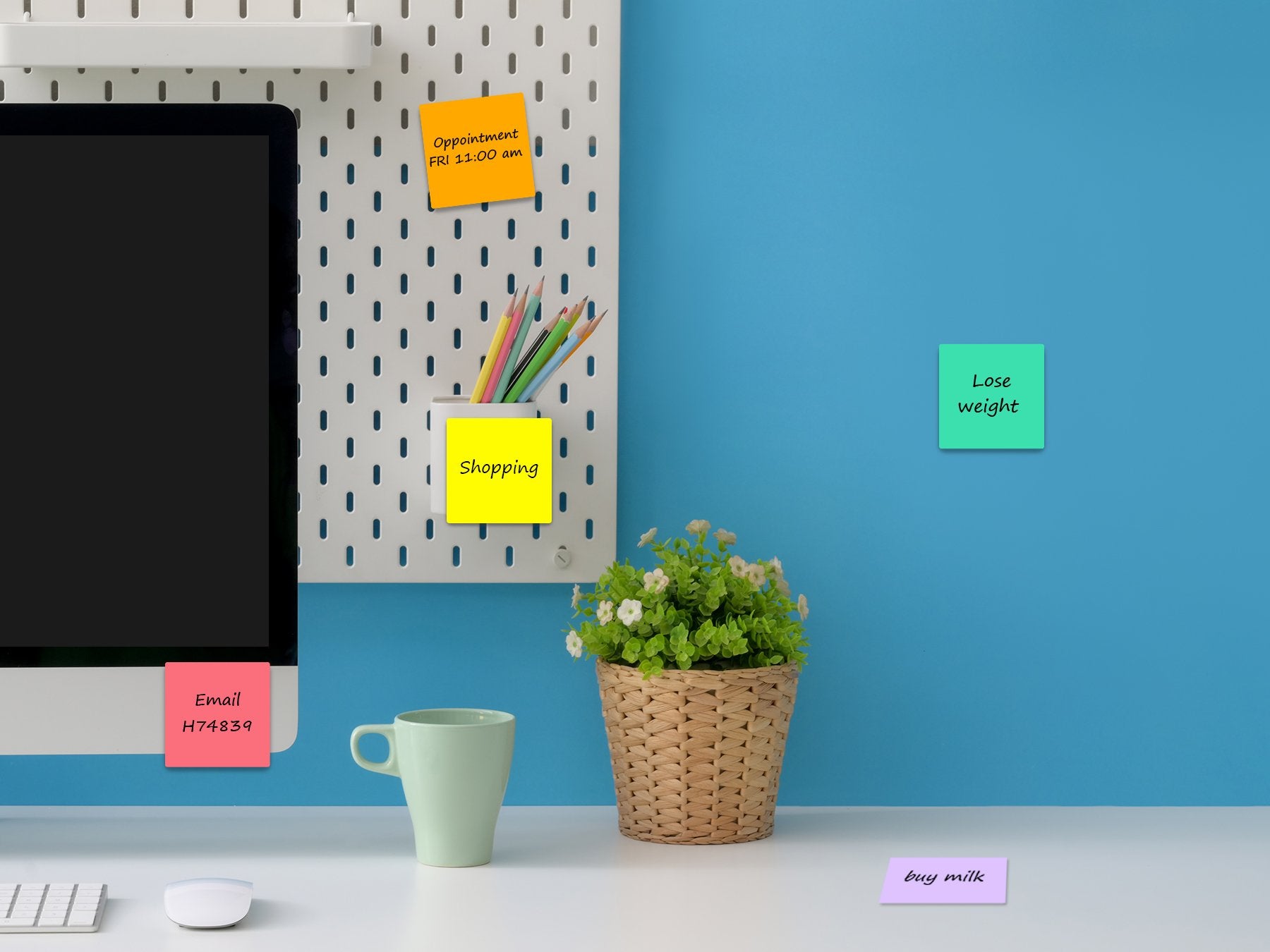 Desk setup with computer monitor, mug, plant, and sticky notes with reminders