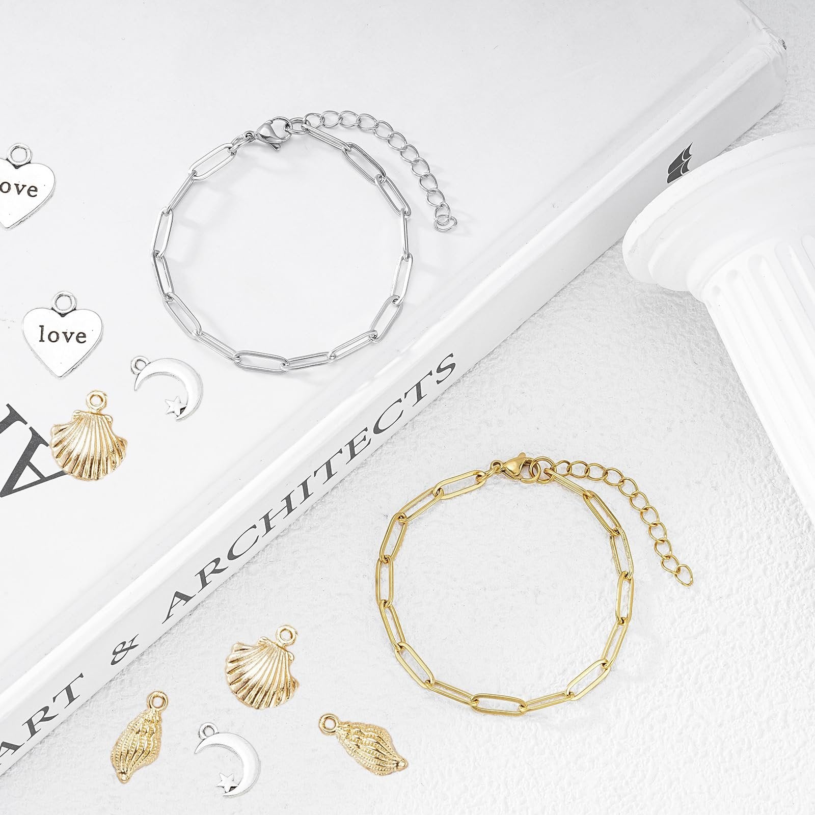 Gold and silver paperclip chain bracelets with assorted charms including shells, moons, and hearts with 'love' text.