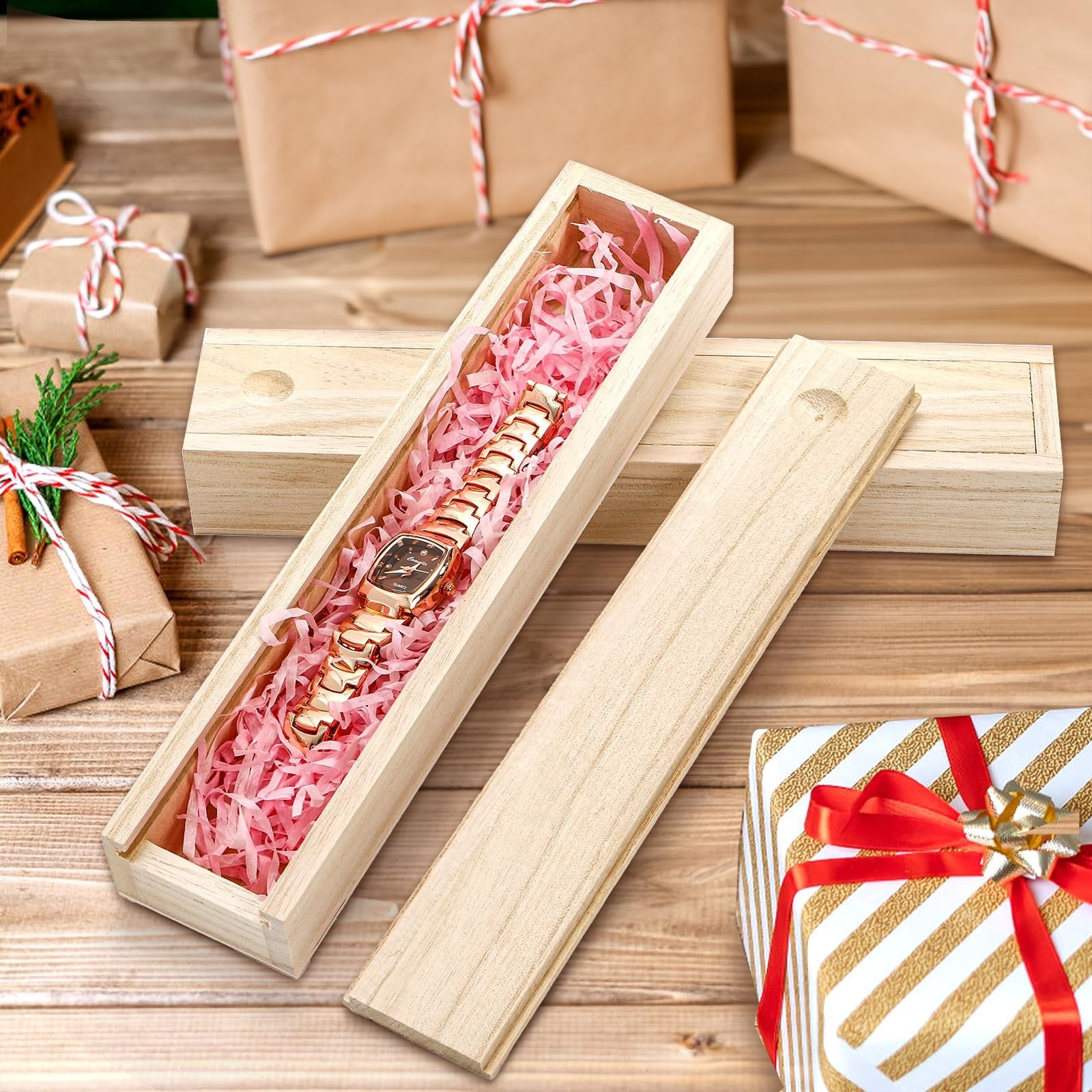 Unfinished pine wood box with sliding lid, open, showing pink shredded paper and a gold watch inside, with gift-wrapped boxes in the background.