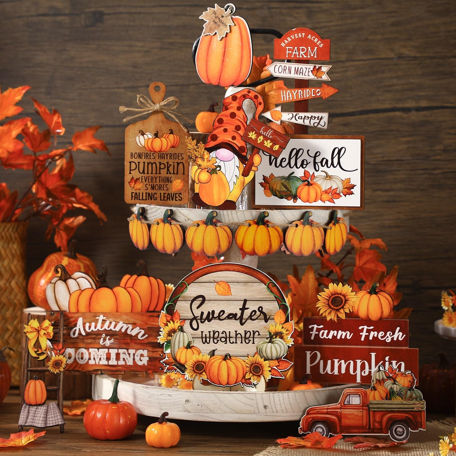 Thanksgiving tiered tray decor with pumpkins, a gnome, and fall-themed signs on a wooden background.