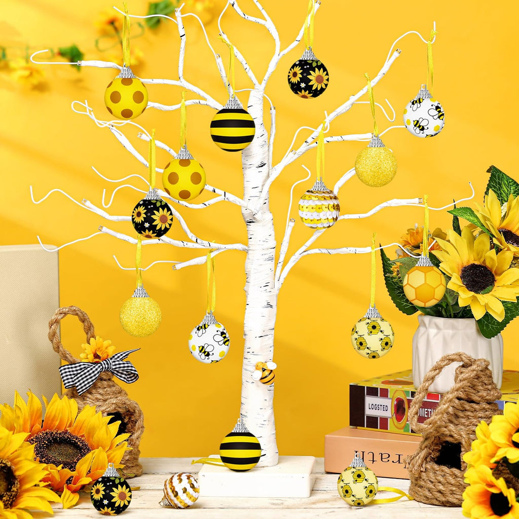 Yellow sunflower and bee ornaments hanging on a white tree with sunflowers and decorative bee houses.