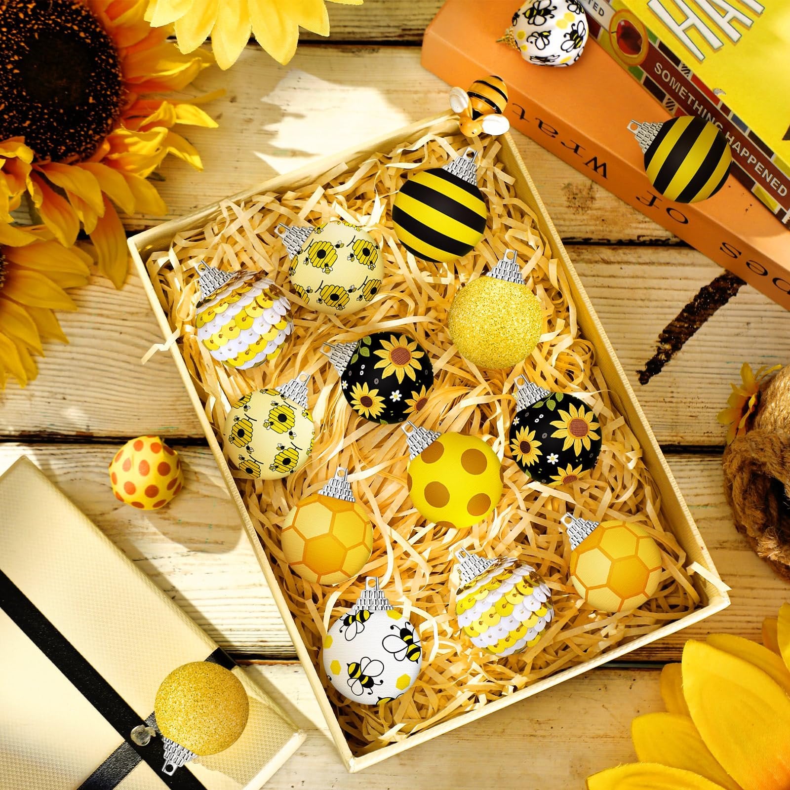 Box of yellow sunflower and bee ornaments with sunflowers and books in background