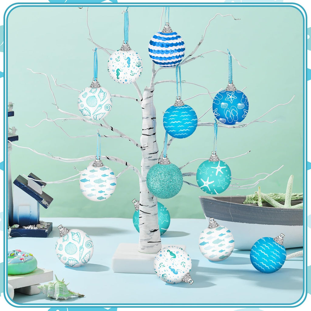 Coastal beach ball ornaments with ocean designs displayed on a white tree branch.
