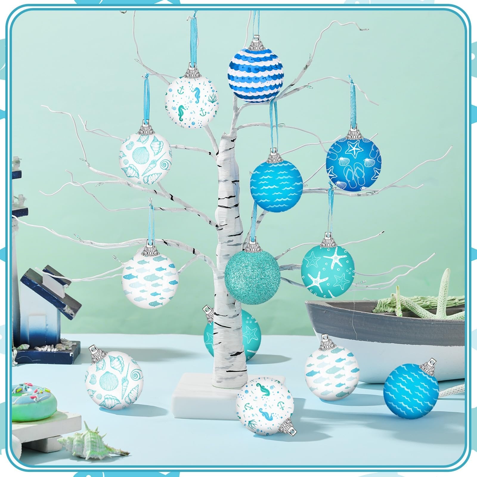 Coastal beach ball ornaments with ocean designs displayed on a white tree branch.
