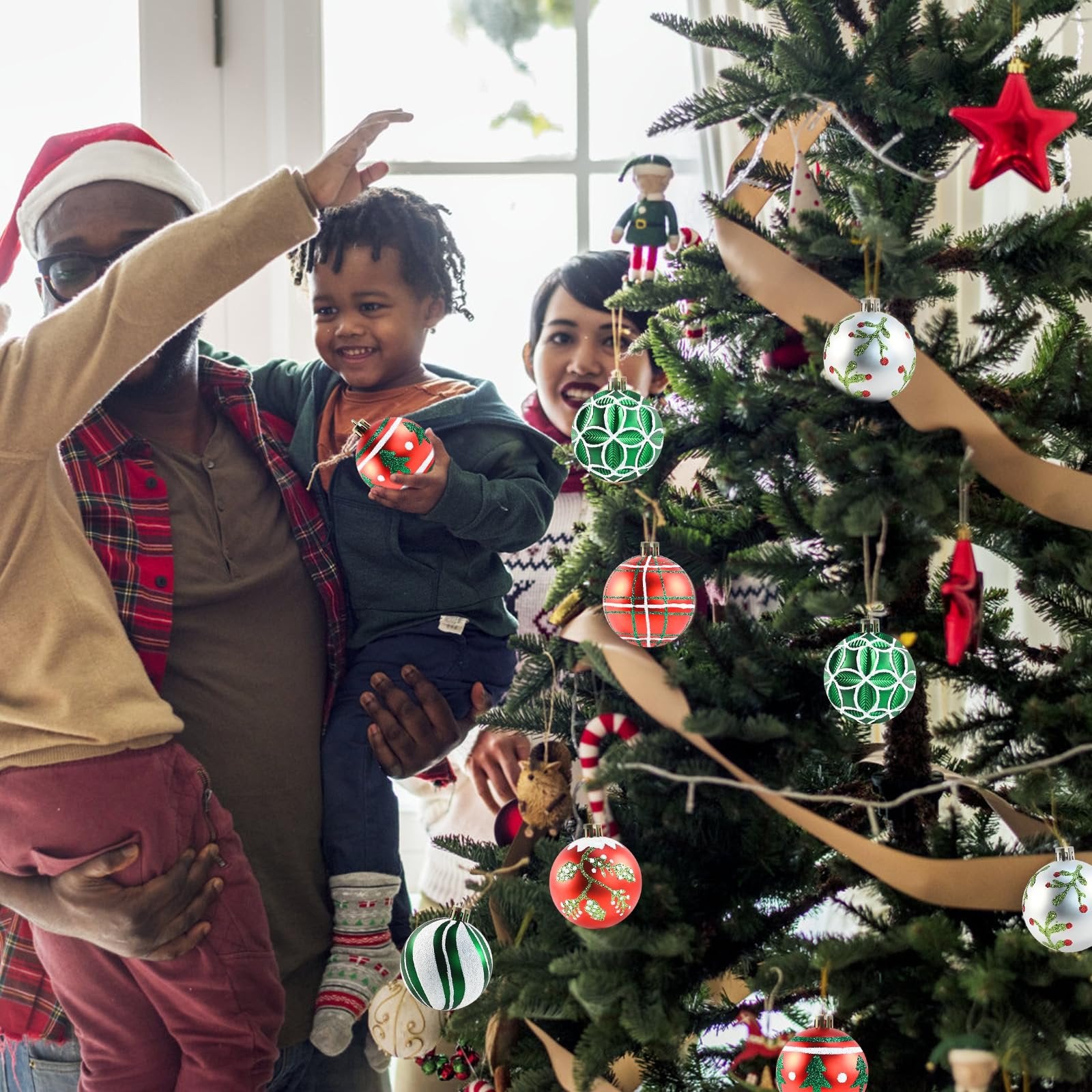Family decorating a Christmas tree with shatterproof ornaments, one child holds a red and white ornament