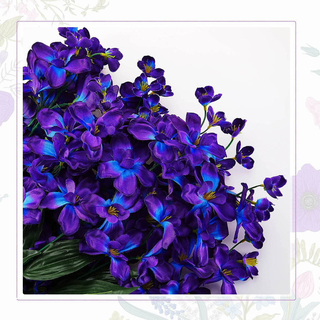 Close-up of a bouquet of artificial blue-purple orchid stems with green leaves against a white background, with decorative floral borders.