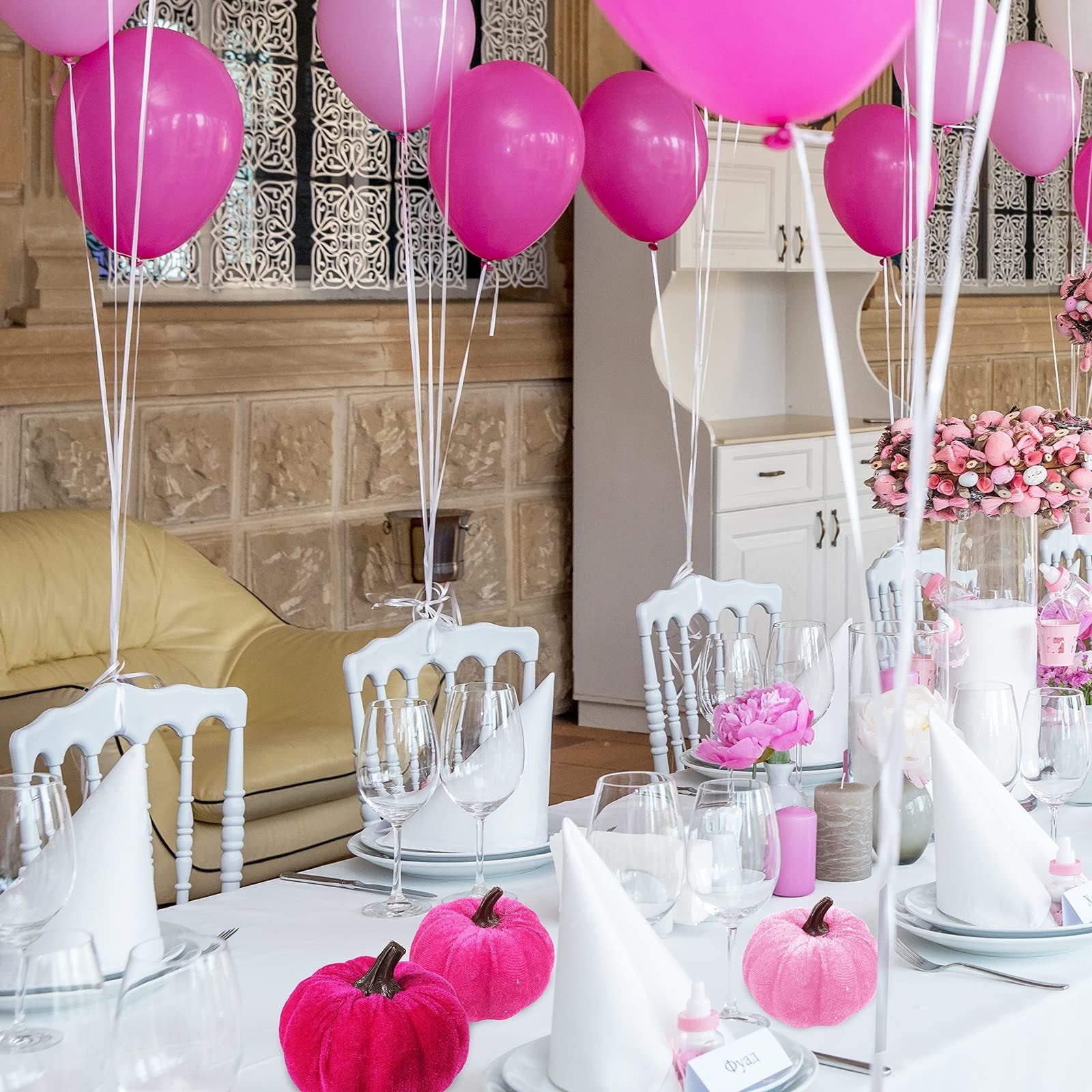 Table setting with pink velvet pumpkins and balloons for a party