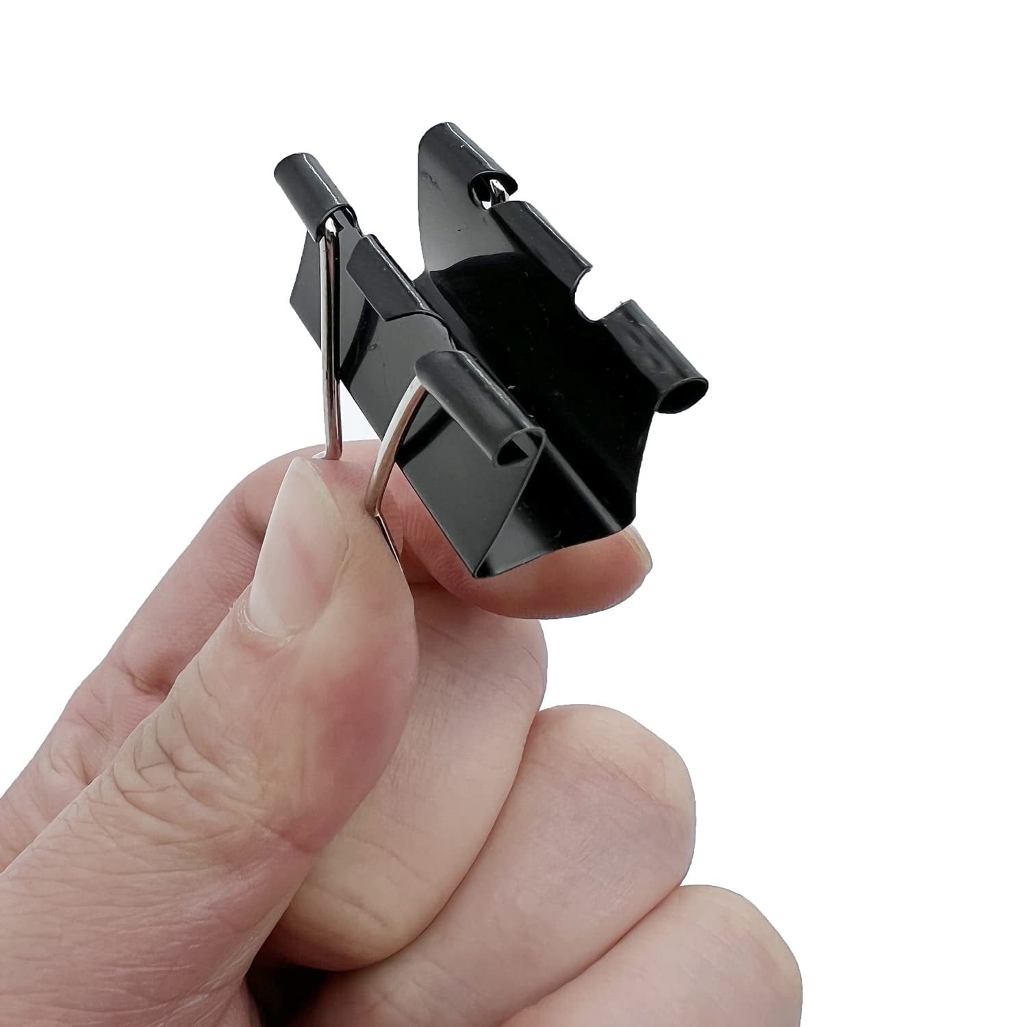 Close-up of a hand holding two black binder clips with silver metal handles against a white background.