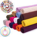Rolled fabric squares in various colors and embroidery floss skeins arranged in a circle with embroidery hoops.