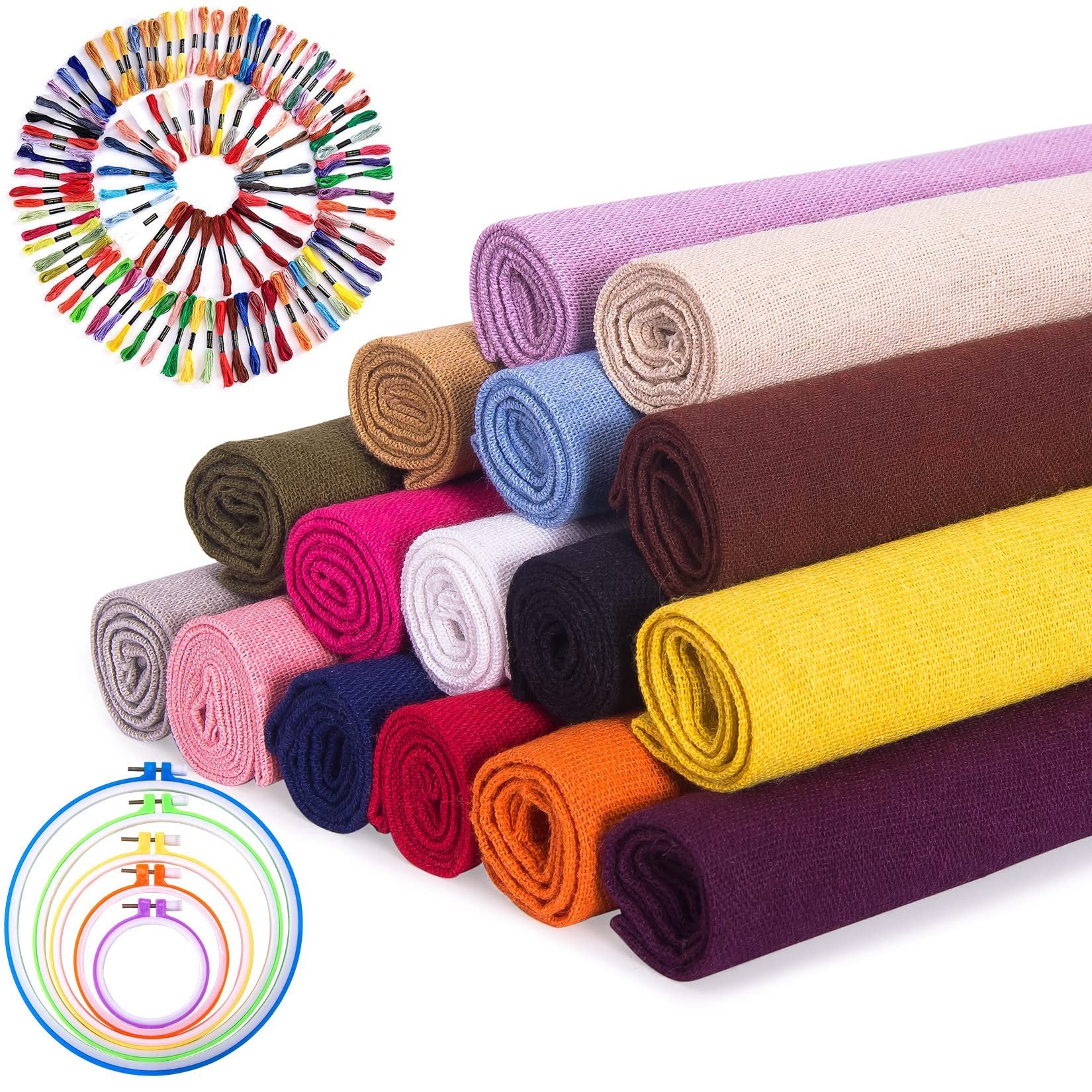 Rolled fabric squares in various colors and embroidery floss skeins arranged in a circle with embroidery hoops.