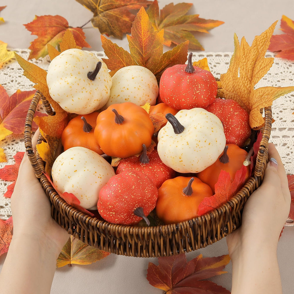 Hands holding a woven basket filled with assorted mini pumpkins and fall leaves, arranged on a lace tablecloth.