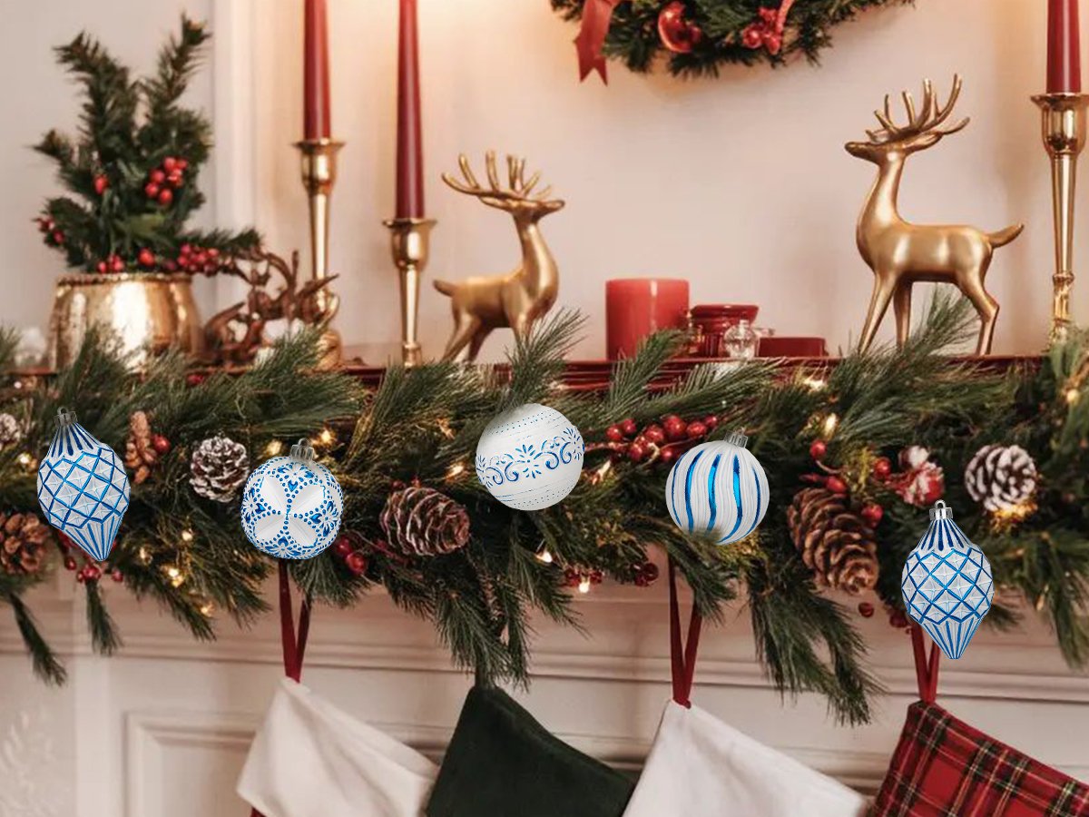 Christmas mantelpiece decorated with pine garland, stockings, reindeer figurines, and assorted blue and white ornaments.