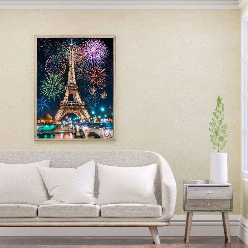 Diamond painting of the Eiffel Tower with fireworks over the Seine river at night, framed and hung on a wall above a sofa.