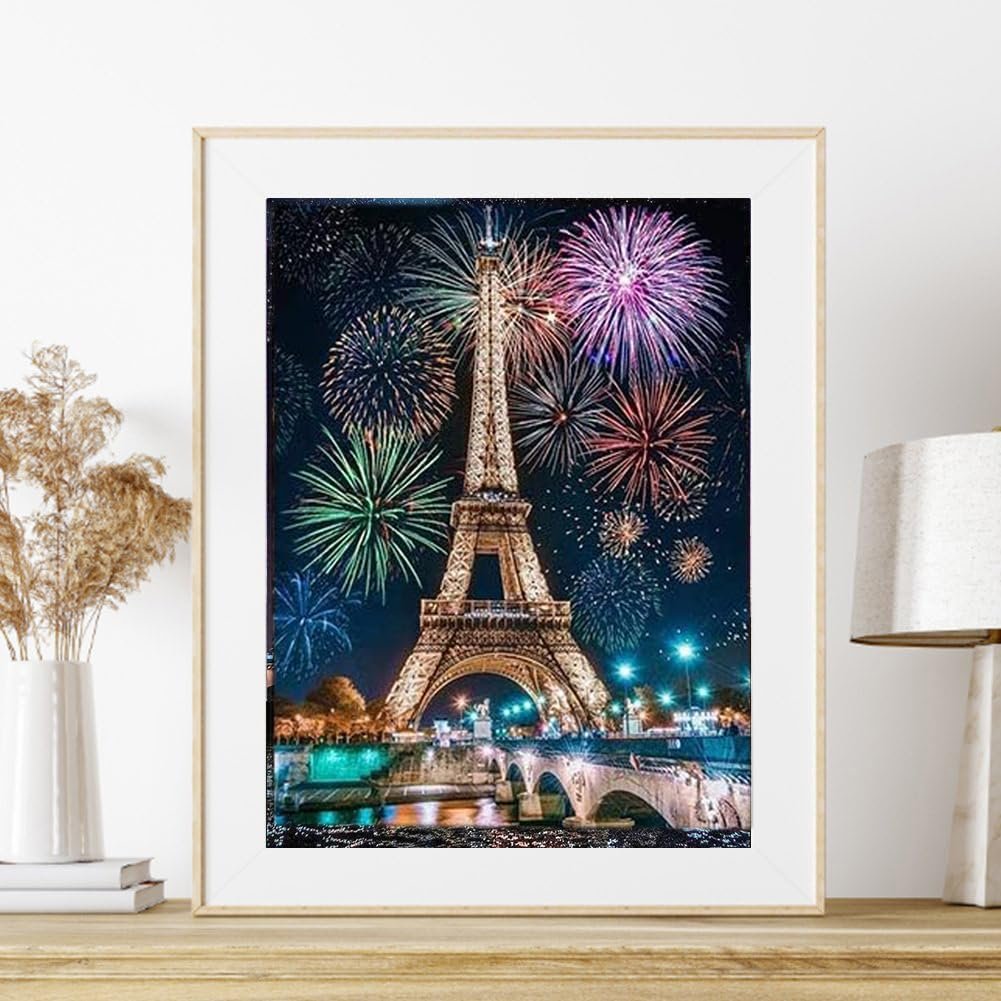 Diamond painting kit featuring the Eiffel Tower at night with fireworks, framed and displayed on a shelf.