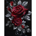 Diamond painting kit featuring deep red roses with dew drops and silver-toned leaves against a black background.