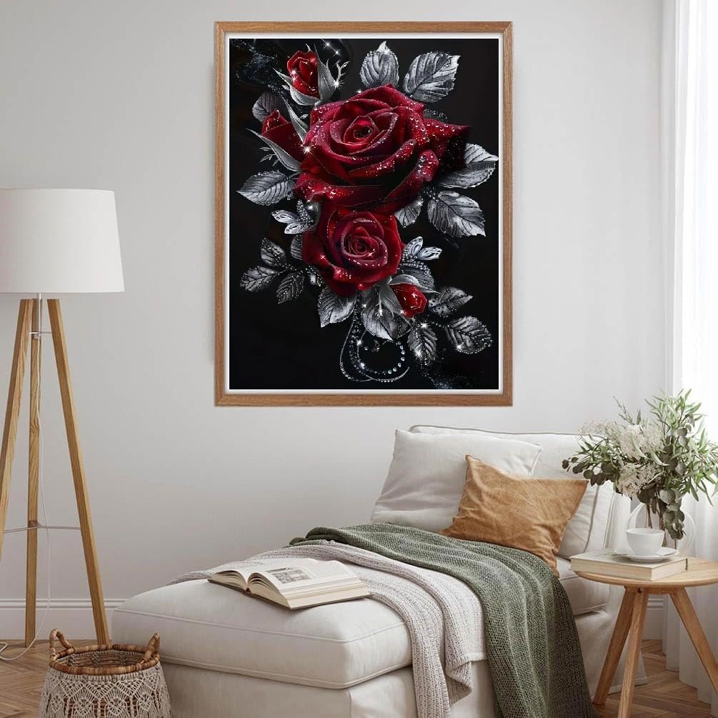 Diamond painting kit featuring red roses with silver leaves on a black background, framed and displayed in a living room setting.