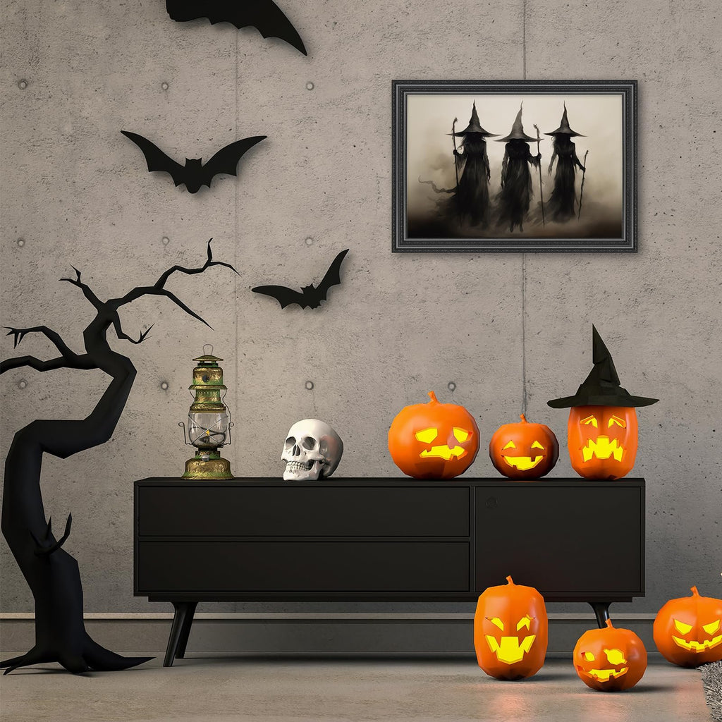 Halloween decor scene with framed art of three witches, jack-o'-lanterns, a skull, a lantern, and a spooky tree on a concrete wall.