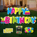 Colorful LED "Happy Birthday" yard signs with stakes and number stickers on a lawn in front of a house.