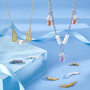 Two necklaces with angel wing charms and loose angel wing metal spacer beads on a blue background.