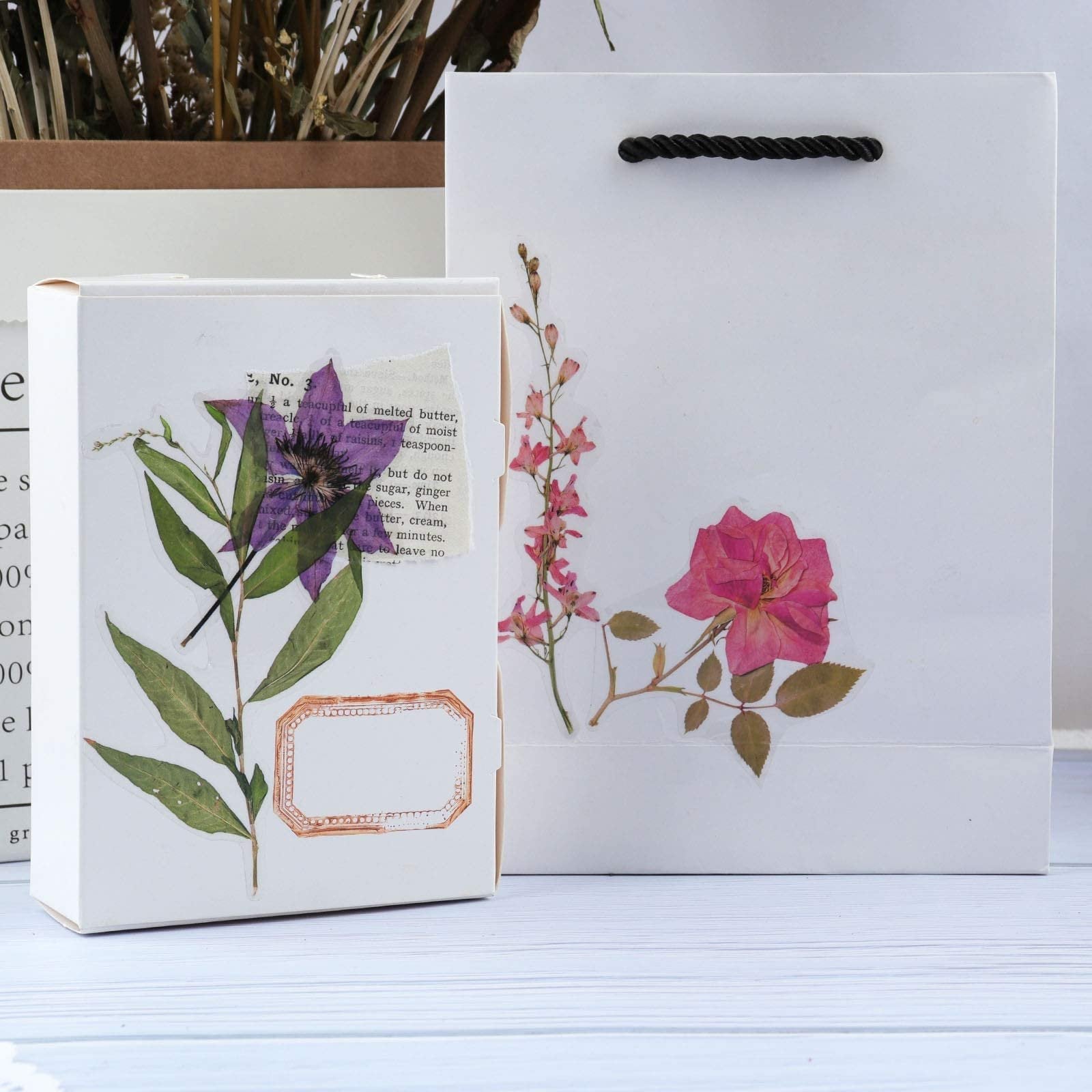 Botanical PET stickers with floral and leaf designs on a white box and gift bag.