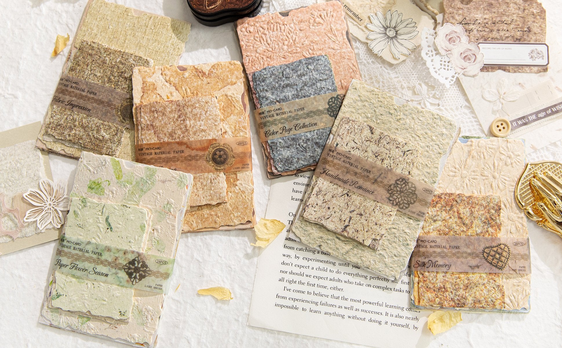 Assorted textured scrapbook paper sheets with decorative bands, arranged in a flat lay.