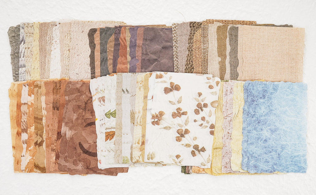 Assorted textured scrapbook papers with natural patterns and colors, laid out in rows.