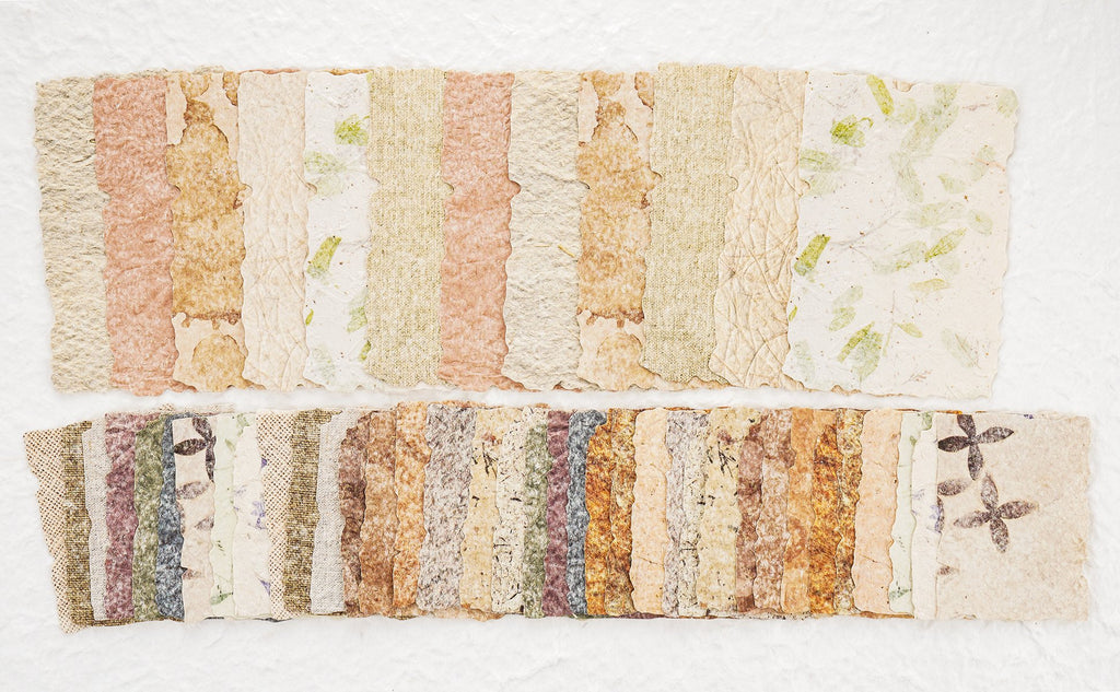 Assorted textured scrapbook paper sheets with embossed patterns and botanical inclusions, arranged in two rows.