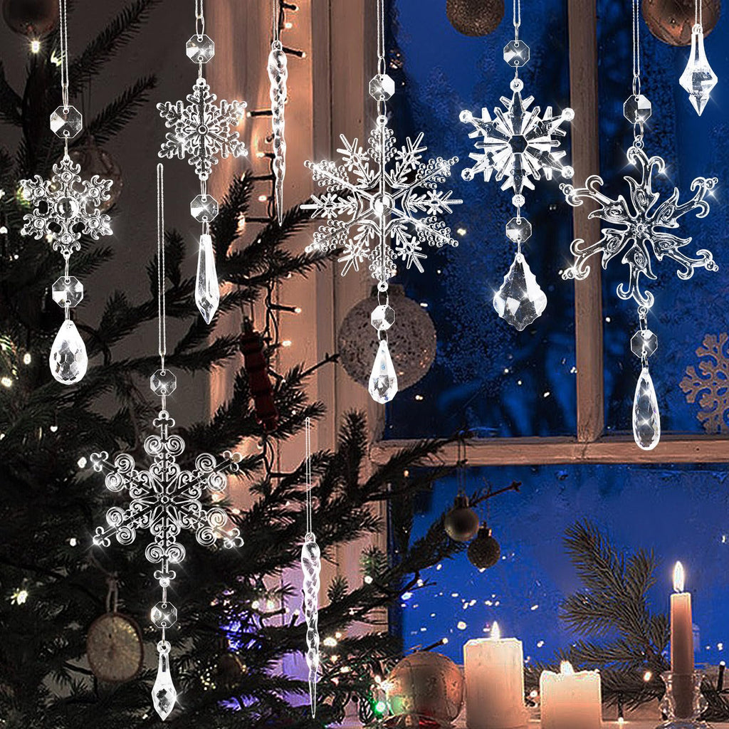 Crystal snowflake and icicle ornaments hanging in front of a window with Christmas lights and candles