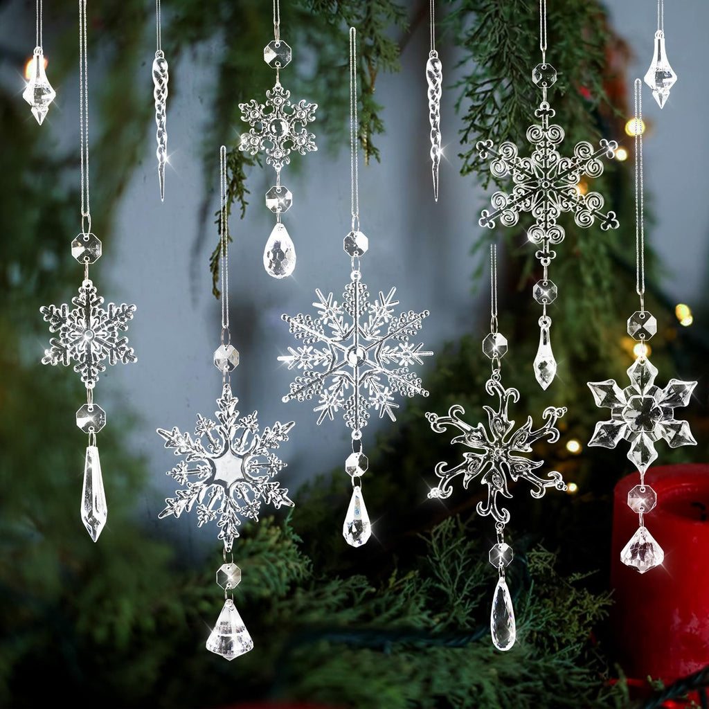Clear crystal snowflake and icicle ornaments with faceted beads hanging against a blurred green and red background.