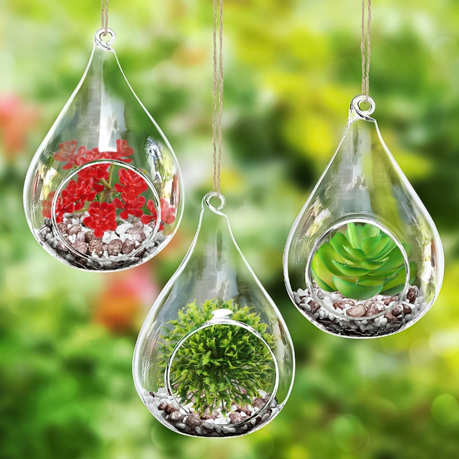 Three teardrop-shaped glass terrariums hanging, each with artificial succulents and pebbles inside, against a blurred green background.