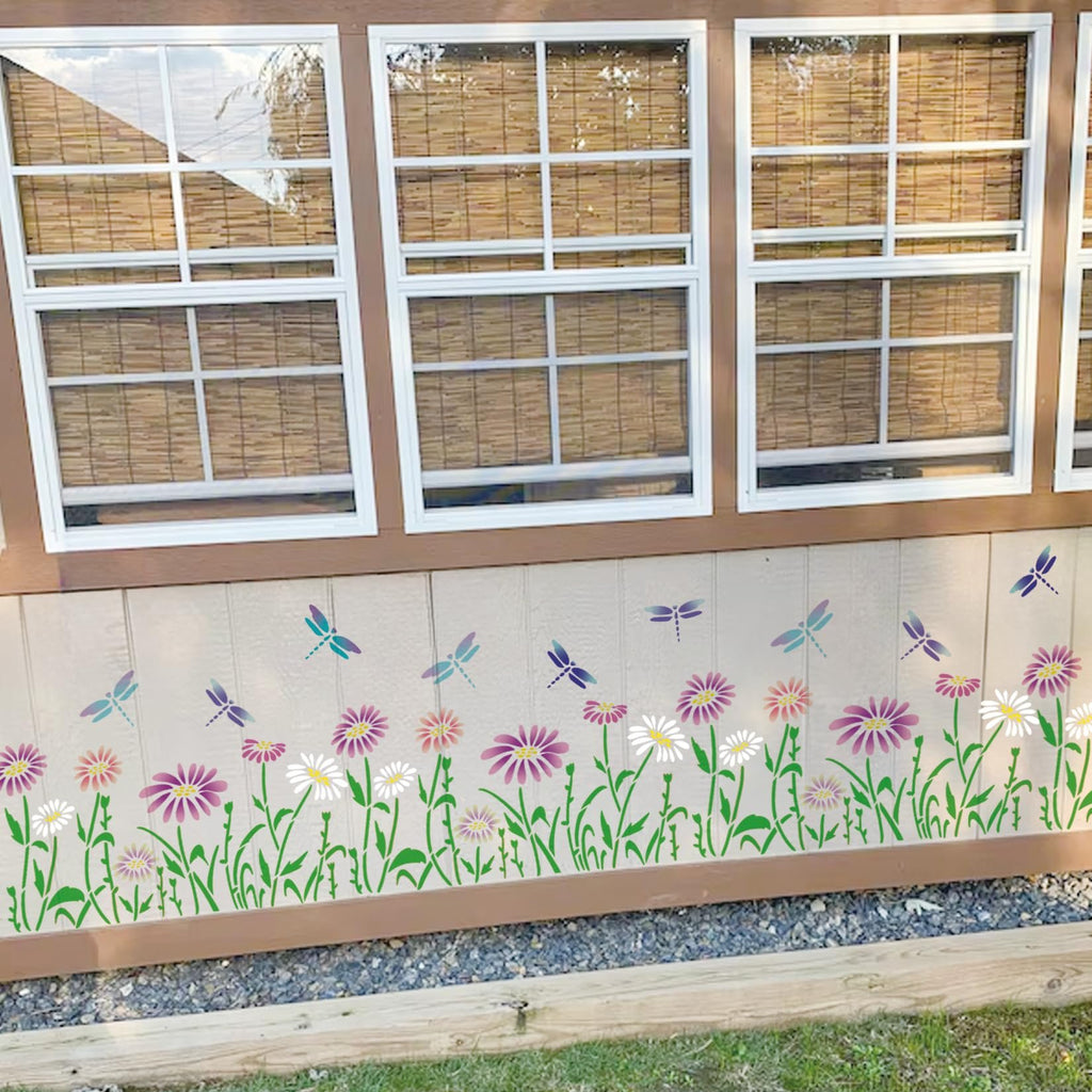 Flower and dragonfly stencil design applied to the side of a building with windows