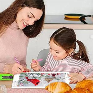 Mother and daughter doing diamond art painting kit with cardinal birds design at a table.