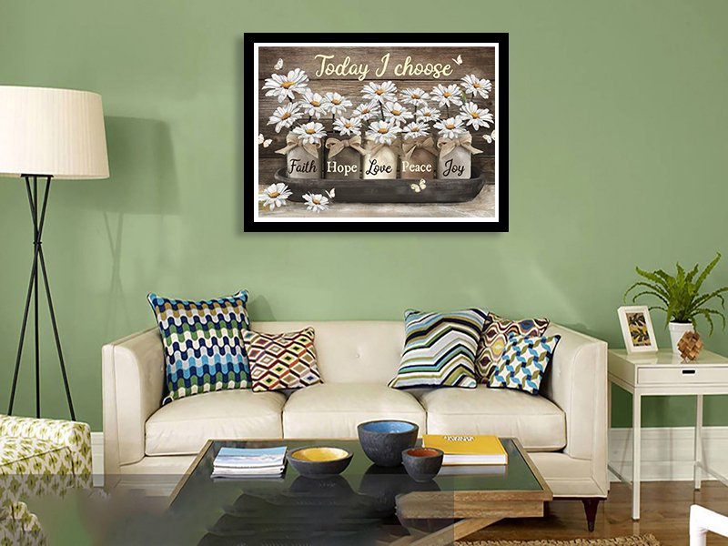 Diamond art painting of daisies in jars with inspirational words, displayed above a sofa.
