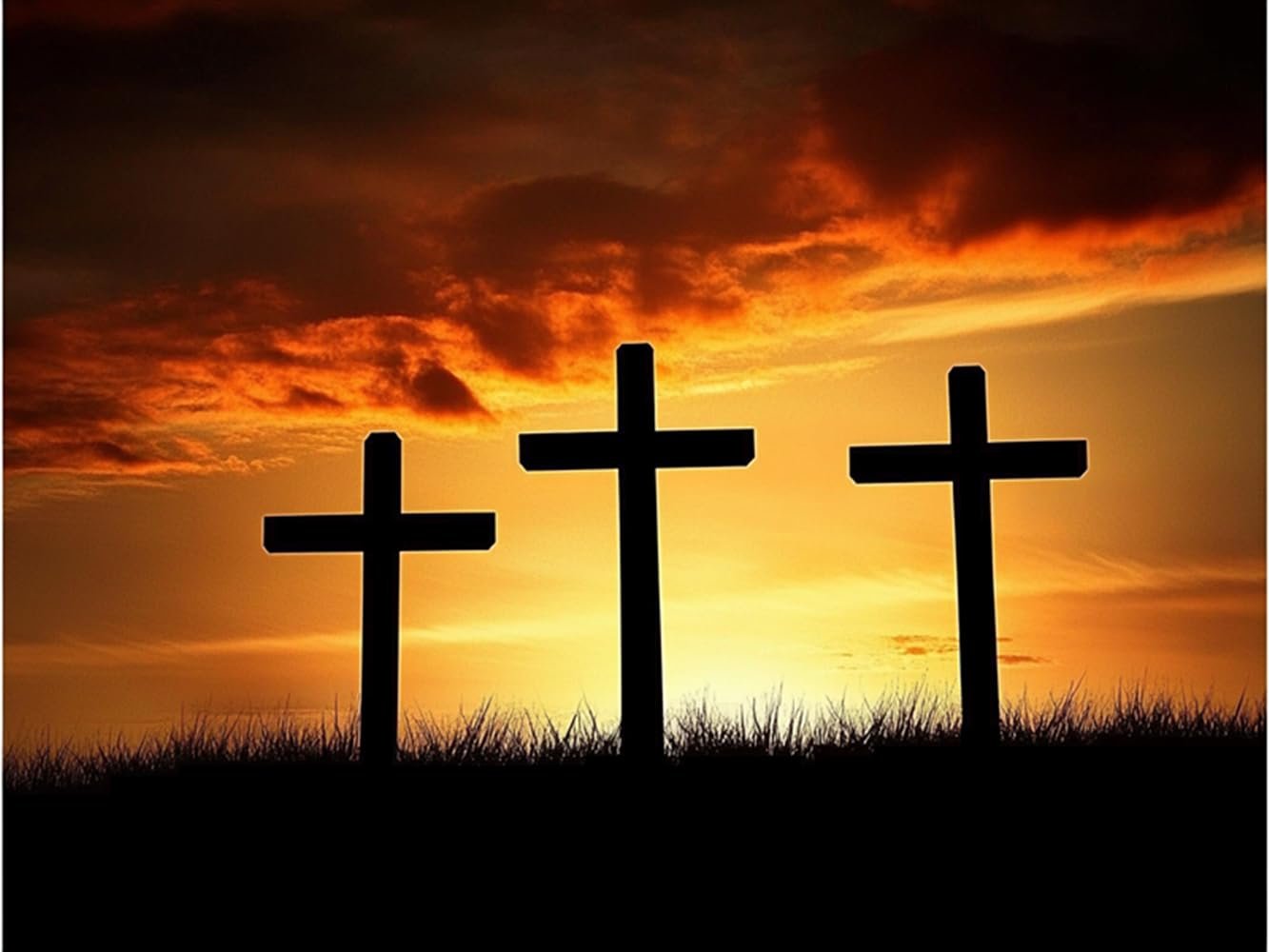 Three black crosses silhouetted against a vibrant orange and yellow sunset sky with dramatic clouds.