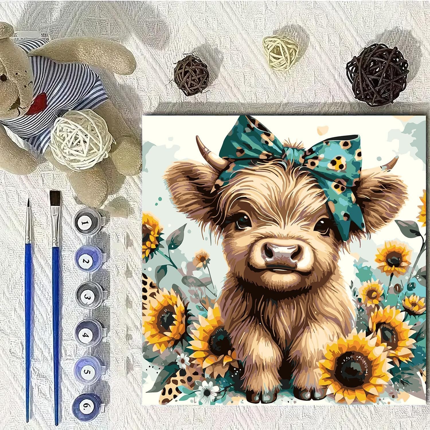 Paint by numbers kit featuring a cute highland cow with sunflowers and paint supplies