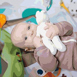 Baby holding a white stuffed toy on a playmat with colorful toys
