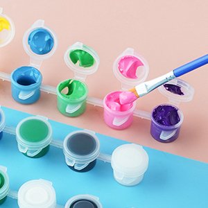 Paint by number kit with small open pots of colorful acrylic paint and a brush dipping into purple paint.