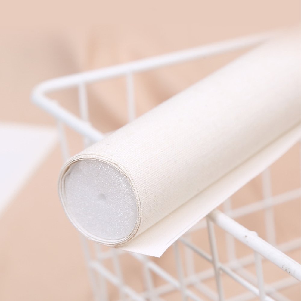 Rolled canvas for paint by numbers kit, resting on a white wire basket.