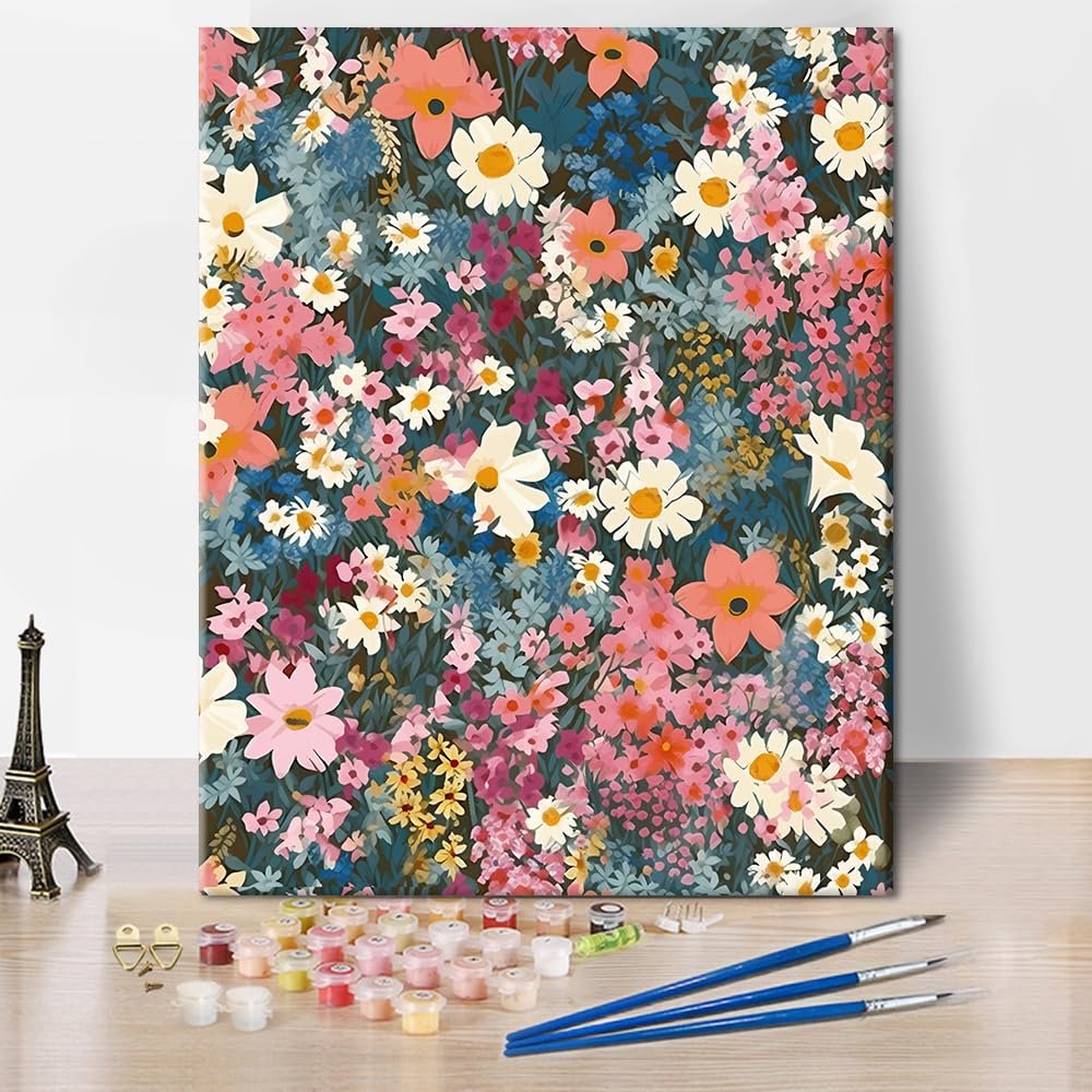 Paint by number kit with paints, brushes, and Eiffel Tower miniature on a wooden table.