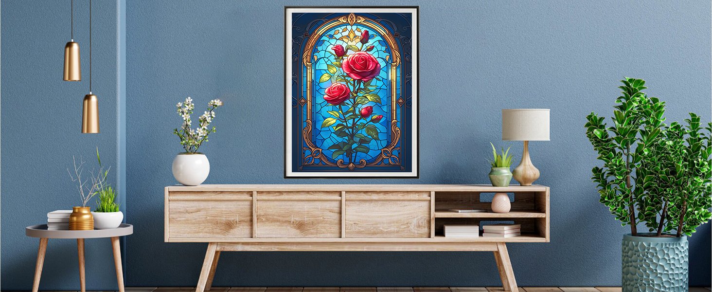 Framed stained glass art of red roses on a blue background, displayed on a wall above a wooden credenza.