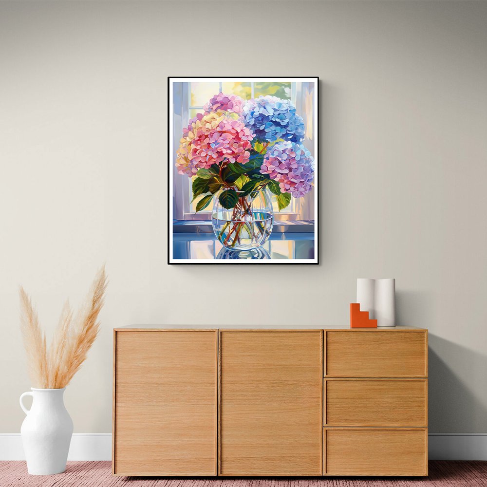 Paint by numbers artwork of colorful hydrangeas in a glass vase on a table, displayed on a wall above a wooden cabinet.