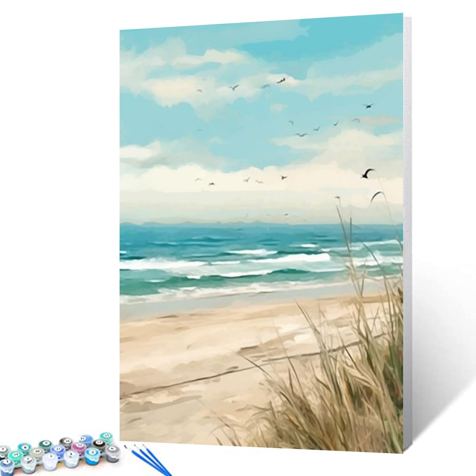 Paint by numbers kit showing a serene beach scene with ocean waves, sand, and grass, with paint pots and brushes in the foreground.