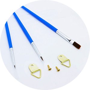 Paint by numbers kit accessories including three brushes and two D-ring hangers with screws on a white background.